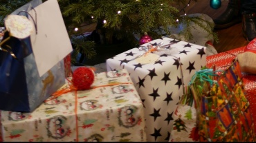 Die 70 Geschenke unter dem Weihnachtsbaum im Jugendhilfezentrum in Saarbrücken warten darauf, geöffnet zu werden. Es freut sich die Betreuerin, Silke Weber (Bild Stadtwerke Saarbrücken). Image